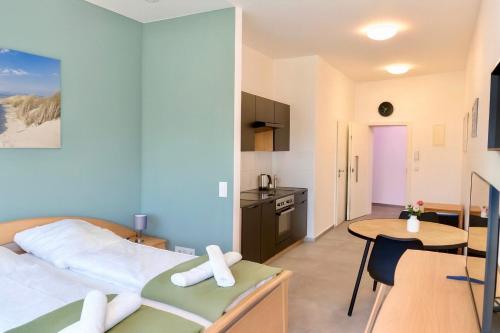 a bedroom with a bed and a table and a kitchen at Ok Apartments in Pforzheim
