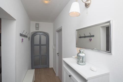 a bathroom with a sink and a tv on a wall at Dalma Residence apartman Lavandella in Zaboric