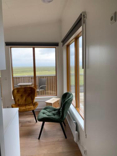 a living room with a chair and a window at Skammidalur cottages in Vík