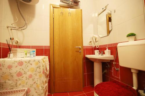 a bathroom with a wooden door and a sink at ILIEVSKI apartment 4 in Kumanovo