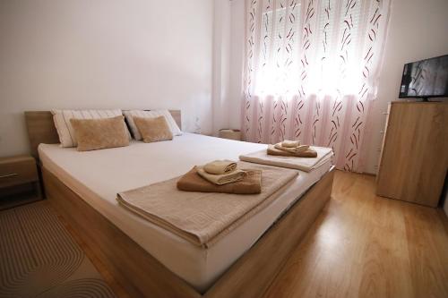 a bedroom with a large bed with towels on it at ILIEVSKI apartment 4 in Kumanovo