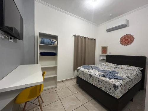 a small bedroom with a bed and a desk and a computer at GOLDEN ROSE HOTEL in Campinas