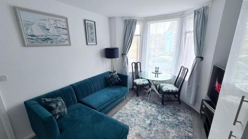 a living room with a green couch and a table at Reverie Escape by Halisi in Ramsgate