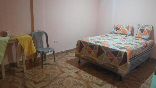 a bedroom with a bed and a table and a chair at Hotel los angeles sjp in San José Pinula