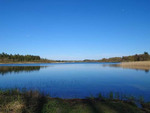 a large blue lake with trees in the background at 4 star holiday home in Hampen in Hampen
