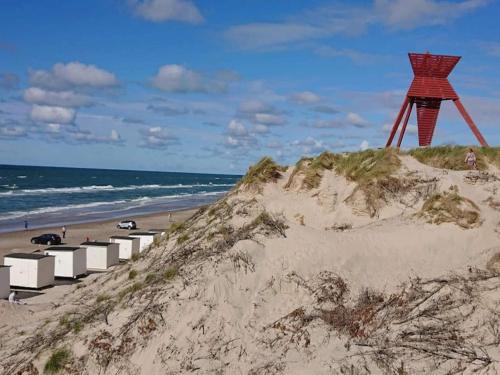 a red structure sitting on top of a sandy beach at 4 star holiday home in Blokhus-By Traum in Blokhus