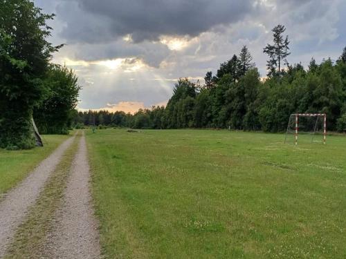 a dirt road in a field with a soccer field at 4 person holiday home in Hampen in Hampen