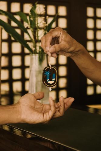 a person holding a key in a persons hands at UNLTD Siargao Hotel in General Luna