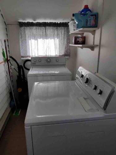 a washing machine in a small kitchen with a window at Cottage on Durango in Tacoma