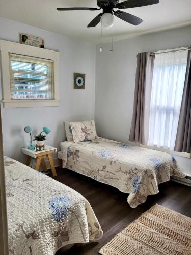 a bedroom with two beds and a ceiling fan at Cottage on Durango in Tacoma