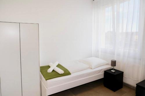 a white bed with a cross on top of it at Ok Apartments in Pforzheim