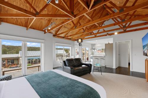 a bedroom with a king sized bed and a couch at Port Central No 2 in Port Campbell