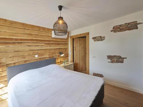 a bedroom with a bed and a wooden wall at De Hoeve III in Hulsel