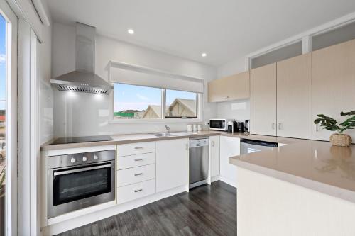 a kitchen with white cabinets and a stove top oven at Port Central No 2 in Port Campbell