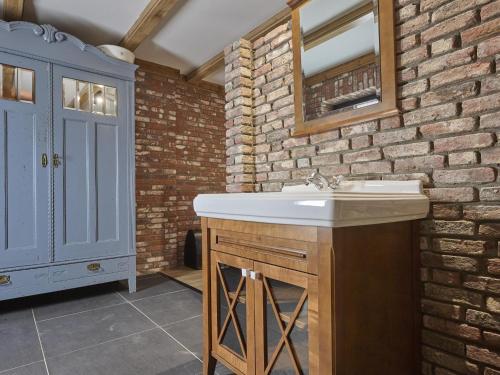 a bathroom with a sink and a brick wall at De Hoeve III in Hulsel