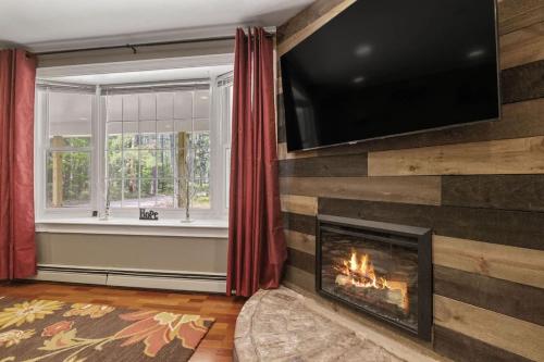a living room with a fireplace and a flat screen tv at Lake Escape Family & Pet Friendly with Dock Access in Freedom