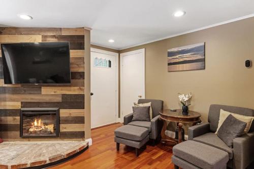 a living room with a fireplace and a flat screen tv at Lake Escape Family & Pet Friendly with Dock Access in Freedom