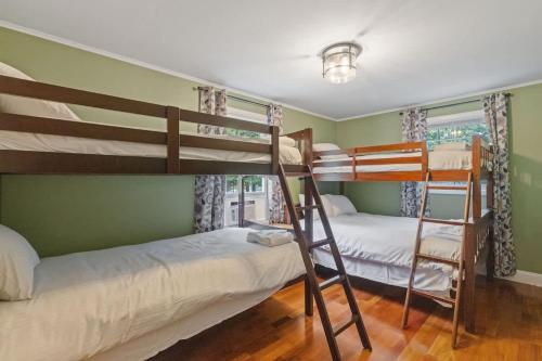 two bunk beds in a room with green walls at Lake Escape Family & Pet Friendly with Dock Access in Freedom