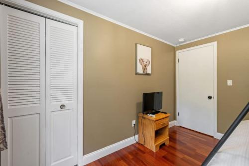 a bedroom with a door and a tv on a wooden table at Lake Escape Family & Pet Friendly with Dock Access in Freedom