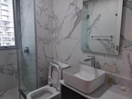 a bathroom with a sink and a toilet and a mirror at Apartment Tower Luxury Home Palace a 100 mts Shopping del Sol con parking amplio in Asuncion