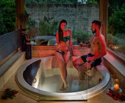 a man and a woman sitting in a bath tub at Agriturismo Valle del Marta in Tarquinia