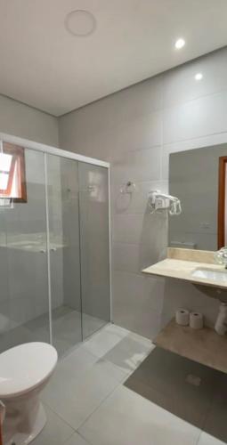 a bathroom with a glass shower and a toilet at Bonatto's House in Cotia