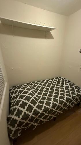 a bedroom with a black and white blanket on a bed at Esjacpe Guest House 2 in Boston