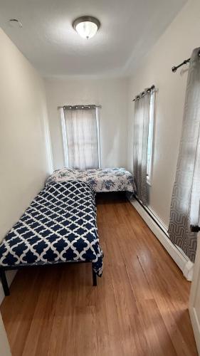 a bedroom with a bed in a room with wooden floors at Esjacpe Guest House 2 in Boston