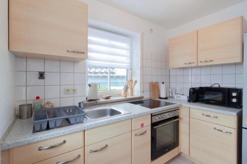 a kitchen with a sink and a microwave at nJoy! Federsee Getaway - Central - Coffee - Balcony - perfect for business and travel in Bad Buchau