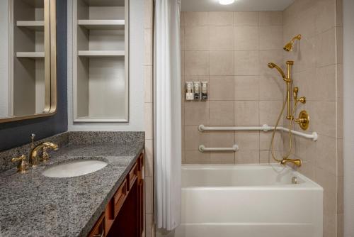 a bathroom with a tub and a sink and a shower at Harrah's Kansas City, A Caesars Destination in Kansas City
