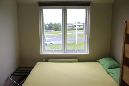 a bedroom with a bed and a window at Lava Hostel in Hafnarfjörður