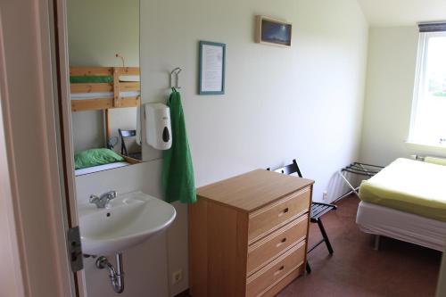a bathroom with a sink and a bed at Lava Hostel in Hafnarfjörður