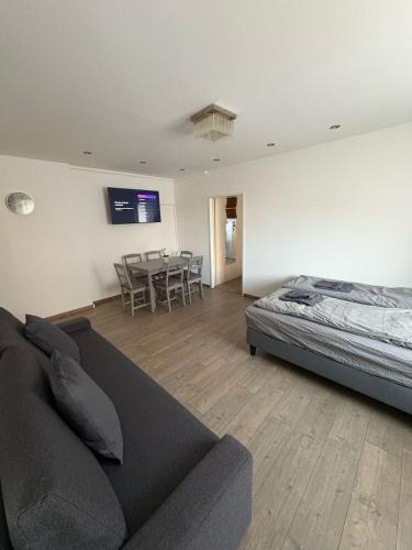 a living room with a bed and a couch and a table at Stylish Apartment near Airport in Schwechat