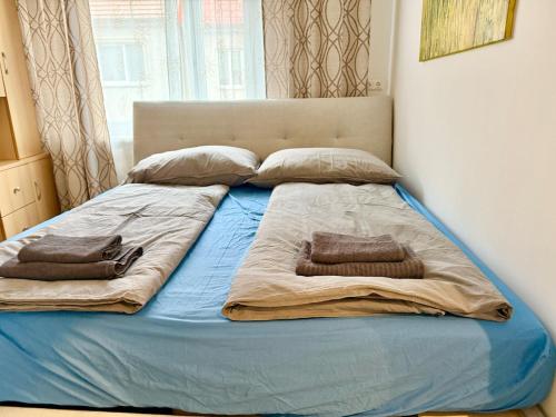 a large bed with two pillows on top of it at Stylish Apartment near Airport in Schwechat