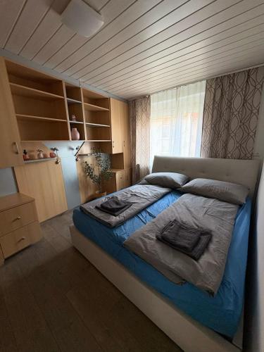 a bedroom with a large bed with blue sheets at Stylish Apartment near Airport in Schwechat