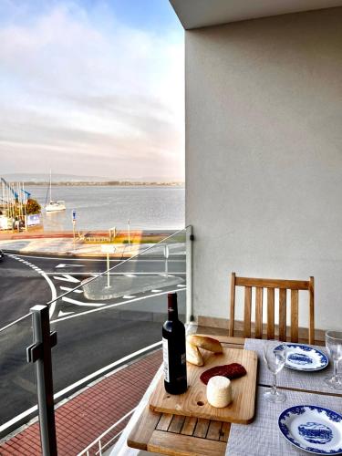 a bottle of wine on a table with a view of the ocean at Apartment Vista Marina in Torreira
