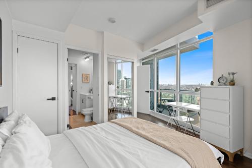 a bedroom with a bed and a view of a city at Apartment with Amazing Views, pool and free parking in Toronto