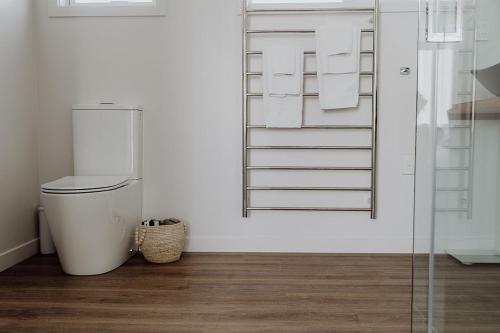a white bathroom with a toilet in a room at Two One Two in Hokitika