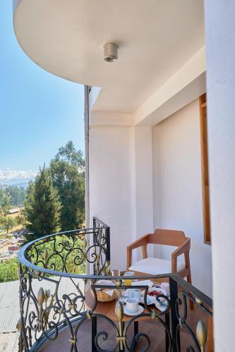 a balcony with a table and a chair and a window at Maimara Hotel in Huaraz