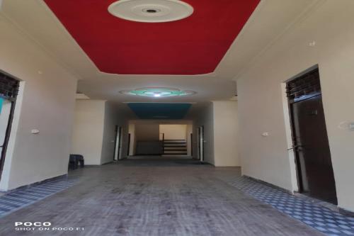 an empty hallway with a red ceiling in an office building at SPOT ON Hotel Abhinandan in Meerut