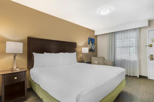 a bedroom with a large white bed and a chair at Best Western Fort Lee in Fort Lee