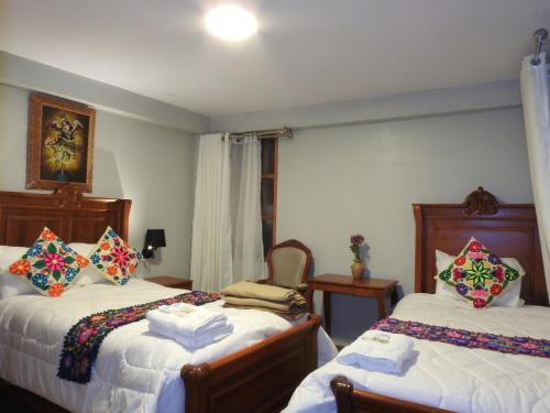 a bedroom with two beds with towels on them at Rumi Wasi Inn Ollantaytambo in Ollantaytambo