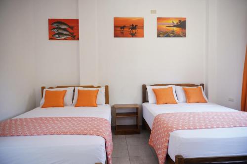 two beds sitting next to each other in a room at Akumal Hotel in Máncora