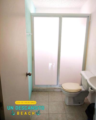 a bathroom with a toilet and a sink and a window at Un descansito Beach in Ixtapa