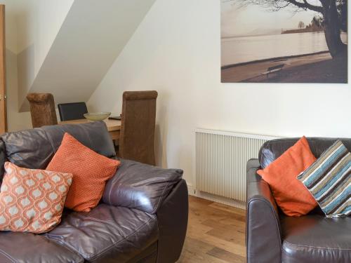 a living room with two leather chairs and a couch at Mews Cottage in Bridlington