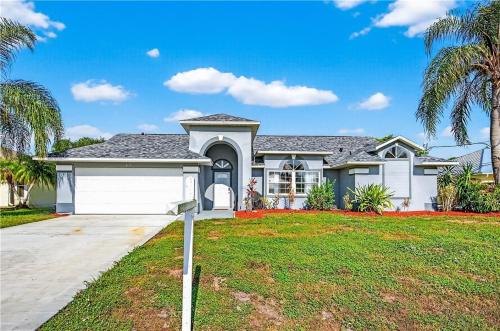 a house with a white garage and palm trees at Relaxing Family Retreat in the Heart of Sebastian home in Sebastian