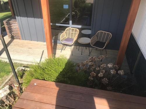 a patio with two chairs and a table on a porch at Aroha Anchor Apartment in Motueka