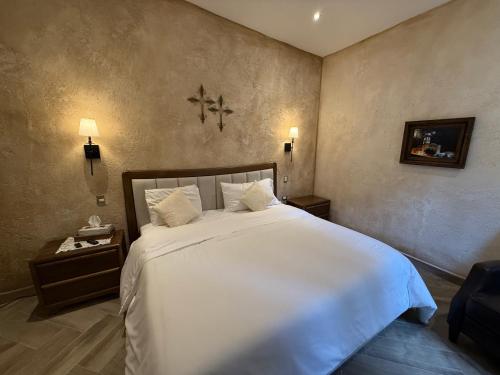a bedroom with a large bed with white sheets at Apolo en ValQuirico in Santeagueda