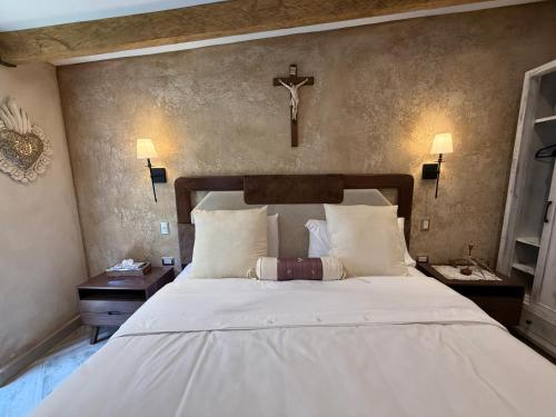 a bedroom with a bed with a cross on the wall at Apolo en ValQuirico in Santeagueda