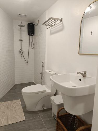 a white bathroom with a toilet and a sink at Panoramic View & Spacious with Swimming Pool Aza Sunset Villa 1 in Langkawi Intl